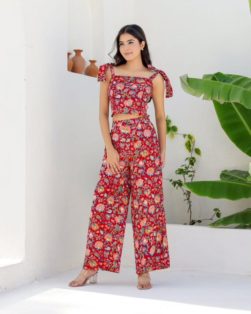 Model wearing Bolbo Cherry Crush red floral coord set with tie-shoulder crop top and wide-leg pants – front view.