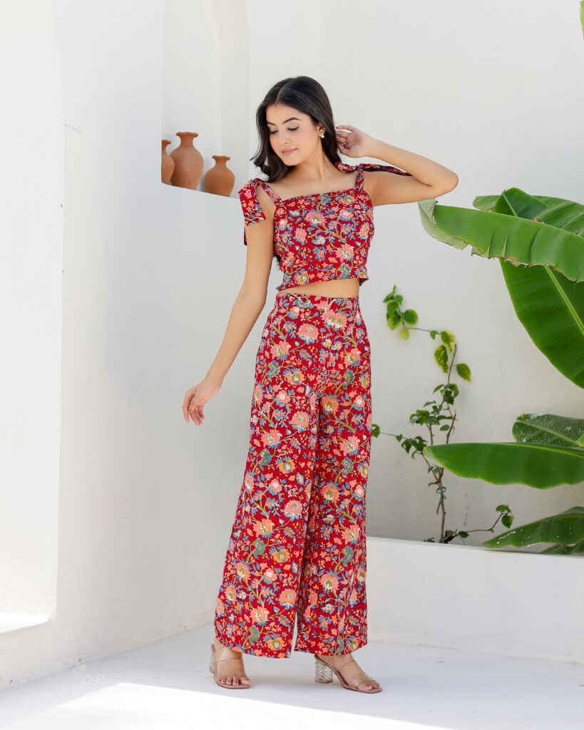 Model wearing Bolbo Cherry Crush red floral coord set with tie-shoulder crop top and wide-leg pants – front view.