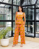 Model wearing Bolbo Sunshine Bloom yellow floral coord set featuring ruffle straps, peplum-style top, and wide-leg pants – front view.