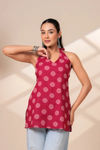 Woman wearing a maroon printed halter neck sleeveless cotton top paired with light blue jeans.